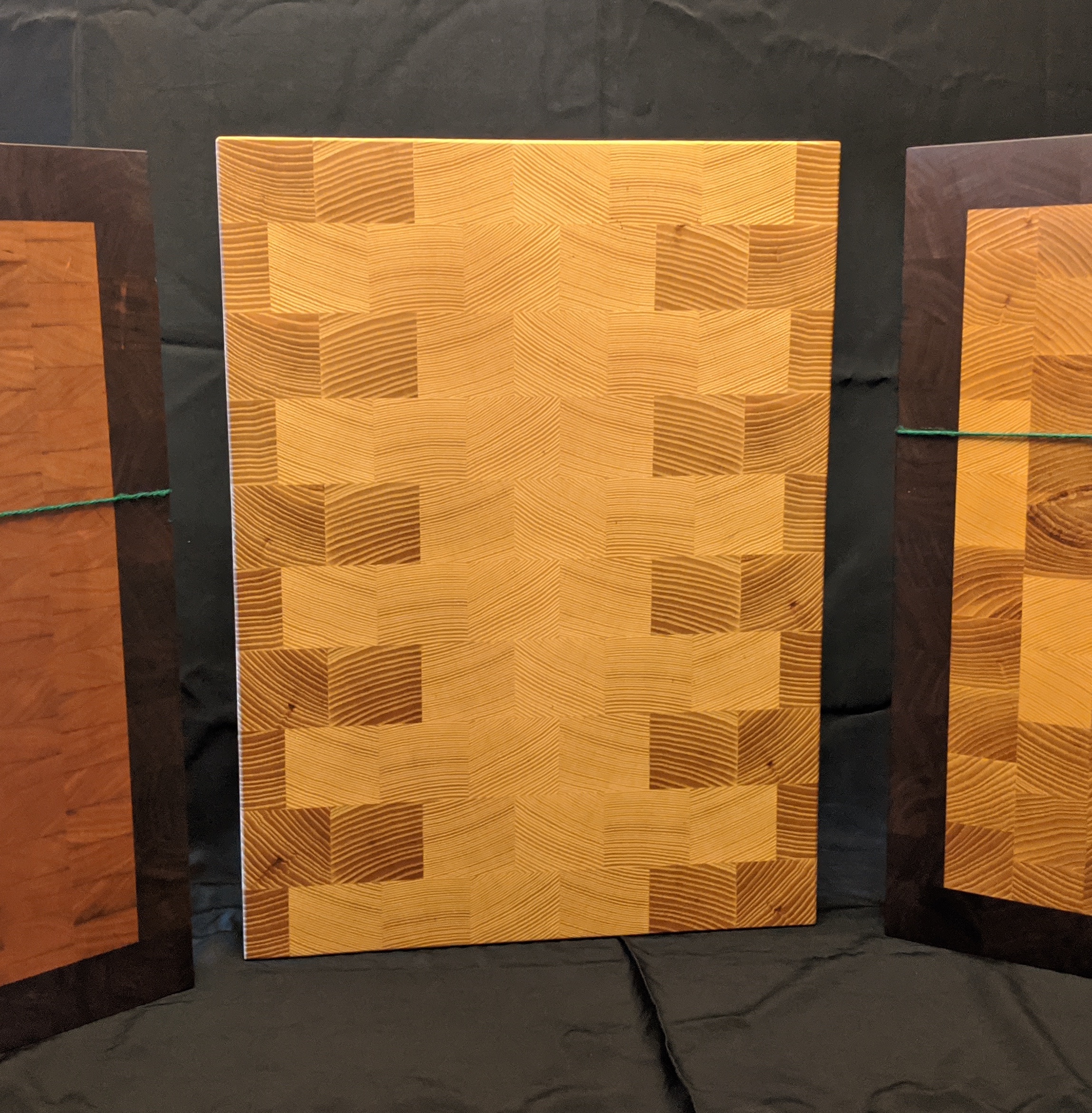 Wooden cutting boards with variegated designs using multiple kinds of wood.