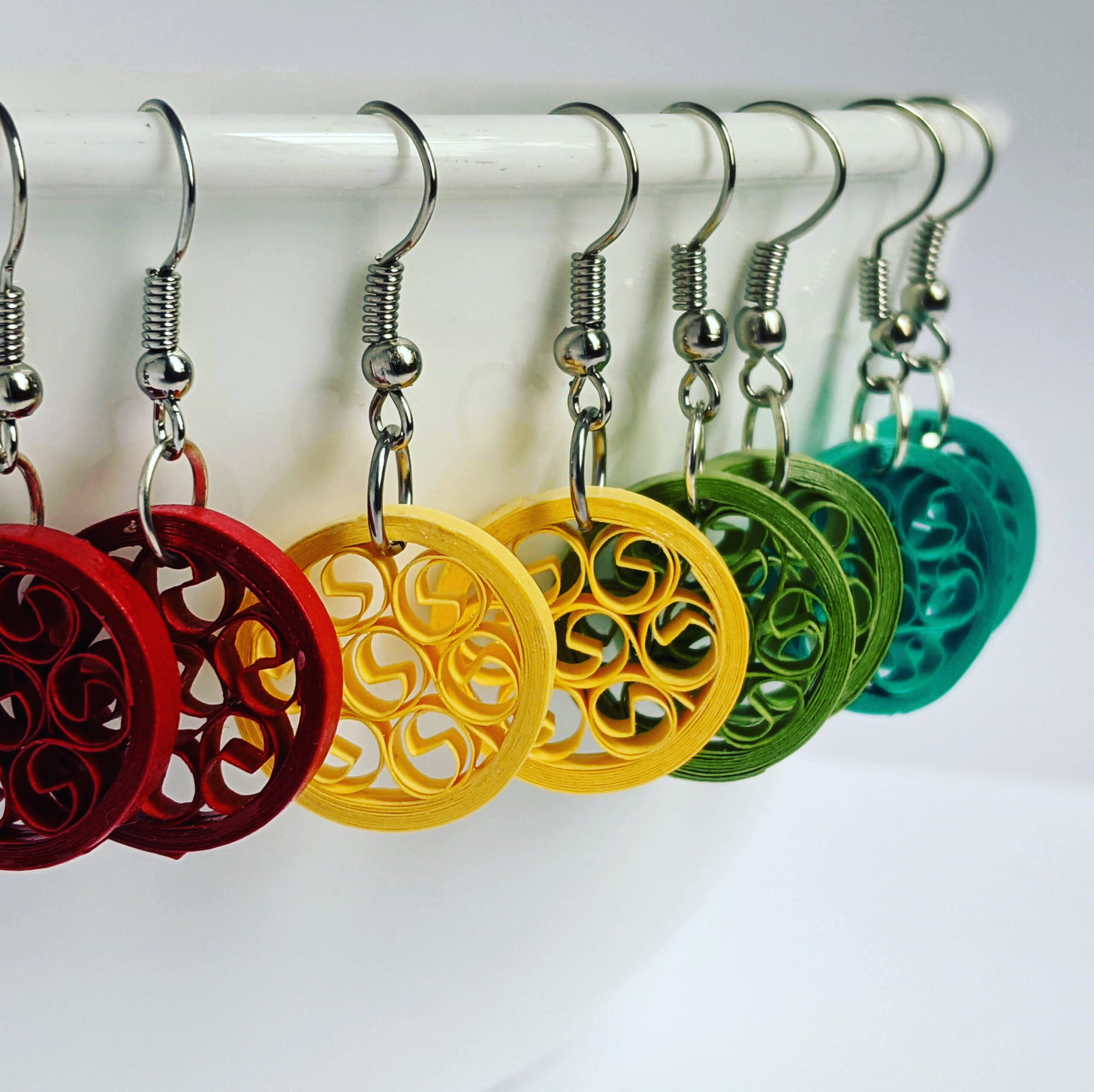 Red, yellow, green, blue quilled earrings made from rolled paper.