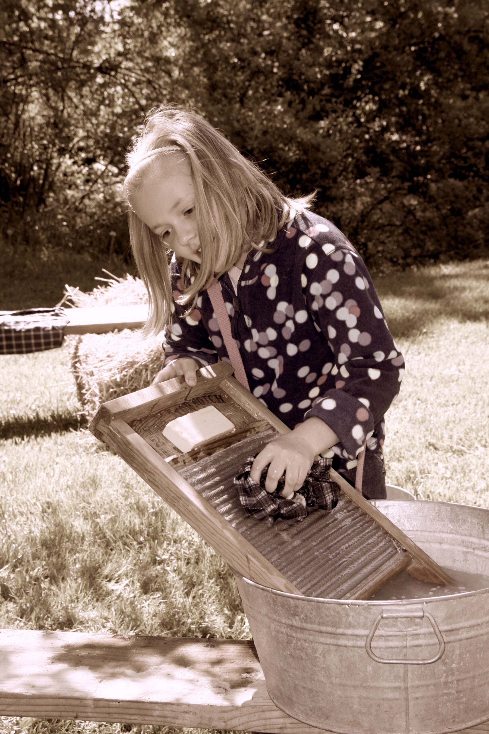 Child uses antique washboard at The Greater Rochester Heritage Days Festival