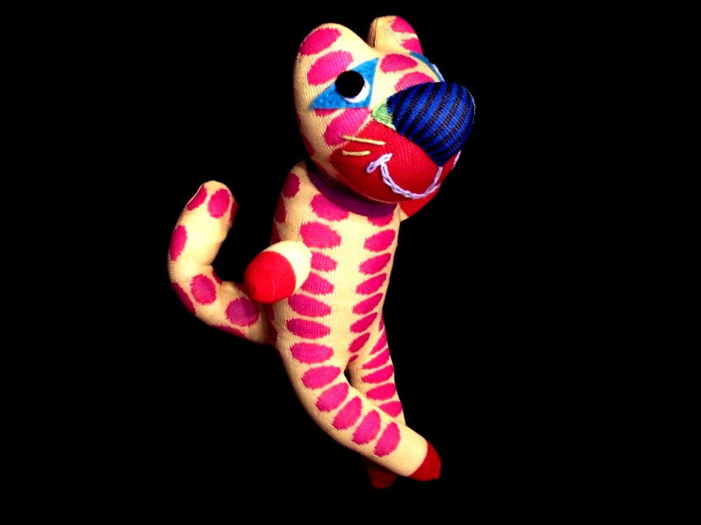 Colorful stuffed animal, resembles a cat. Handmade by "My First Pal"