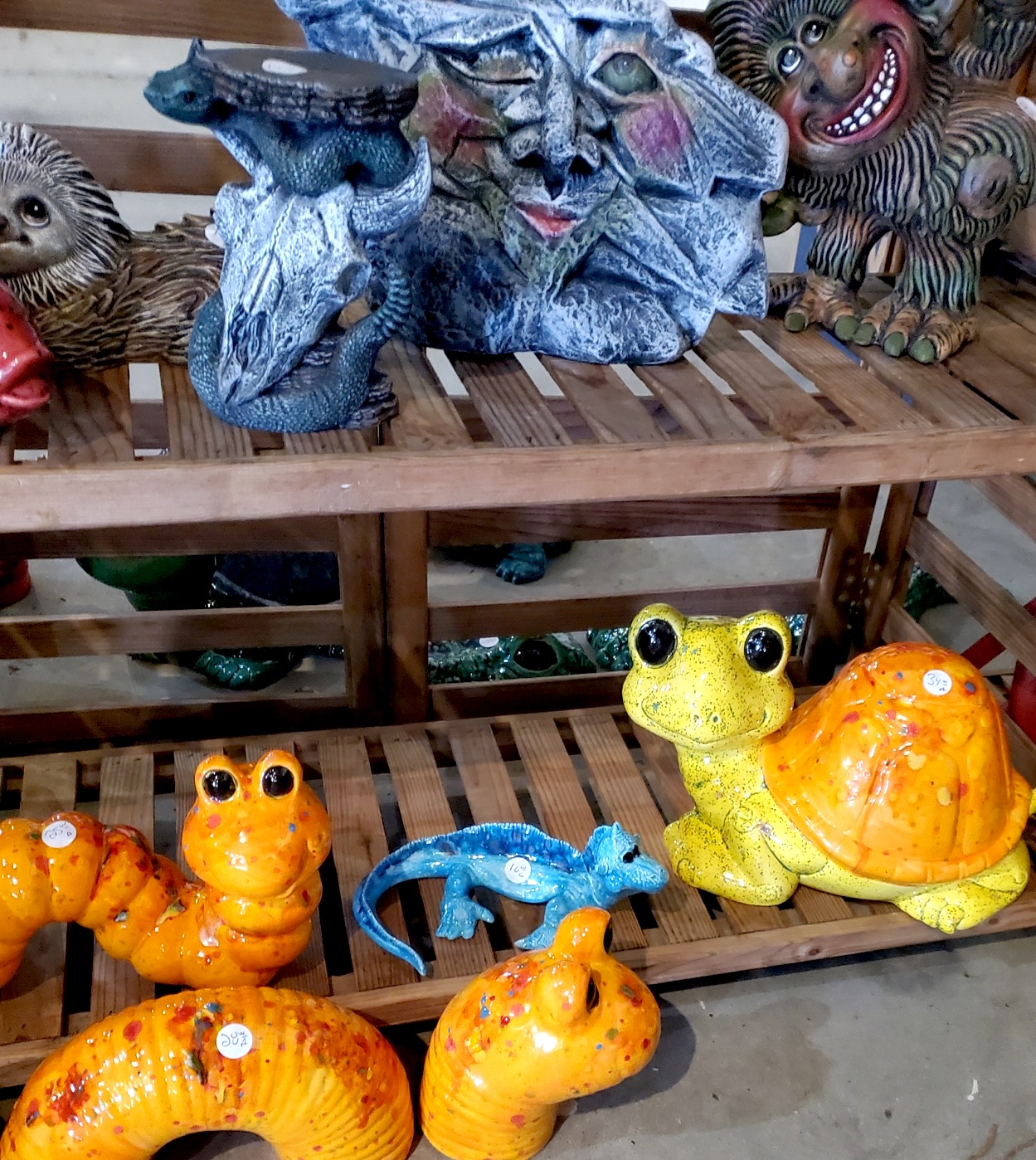 Brightly colored ceramic creatures. A yellow and orange turtle, aqua lizard, purple tree trunk, and dancing troll adorn April Evans booth at The Greater Rochester Heritage Days Festival.
