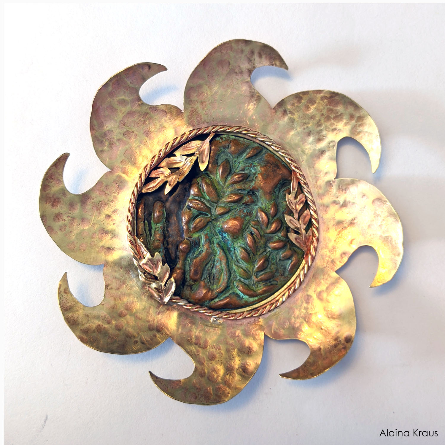 Bright copper sun with designs in the middle. Handmade in Michigan by Alaina Kraus.