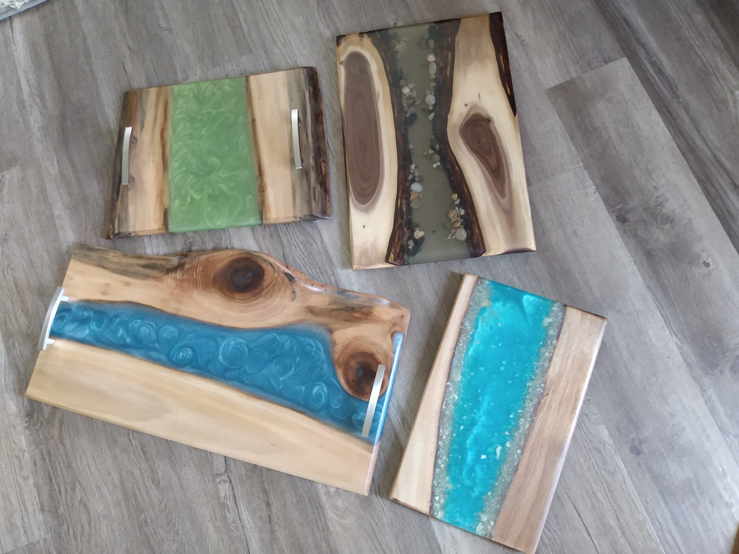 Four wooden cutting boards with epoxy poured in the center.