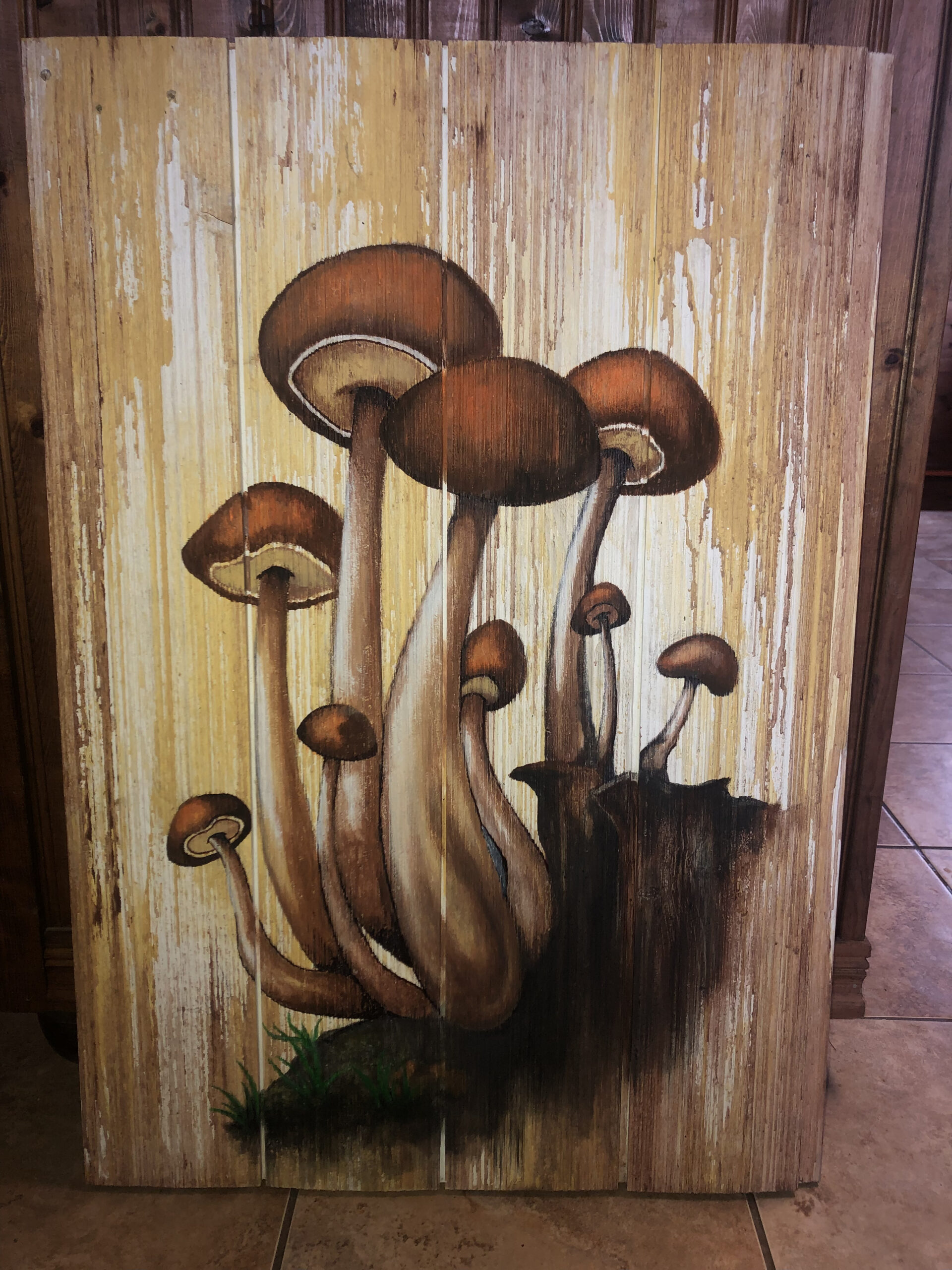 Hand painted mushrooms in Earth-tone colors onto wooden board.